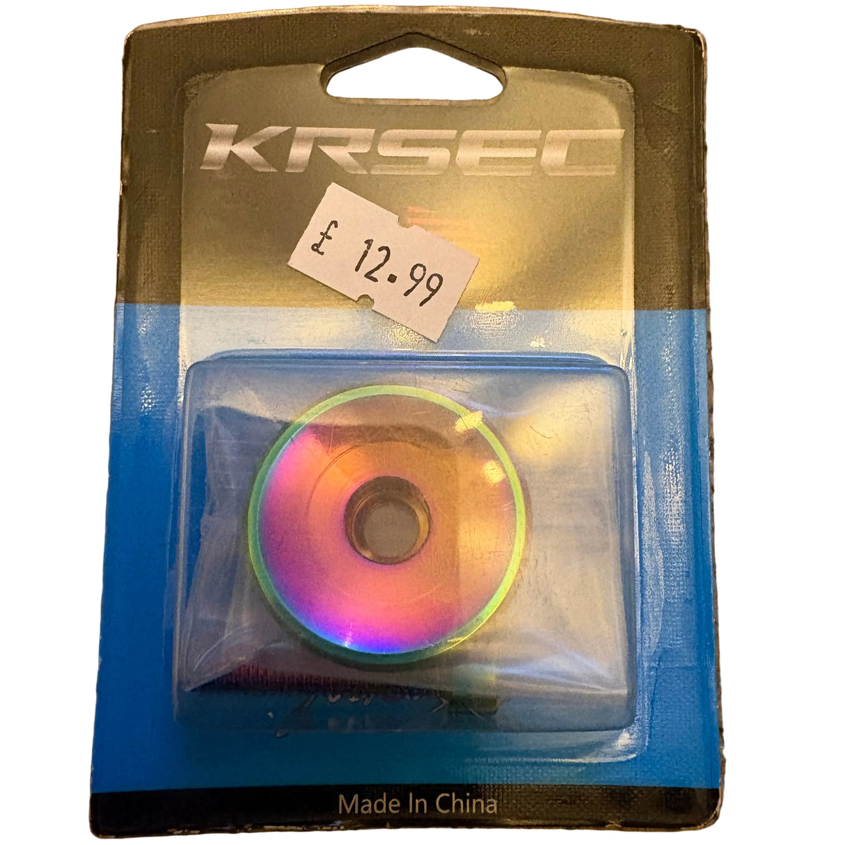SSS Racing Stem Headset Top Cap in rainbow anodized aluminum, circular finish with gradient hues and silver threads.