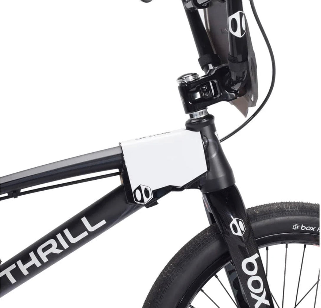 Box Two BMX Side Number Plate by SSS Racing, white aluminum plate with black accents mounted on a black frame nearby fork.