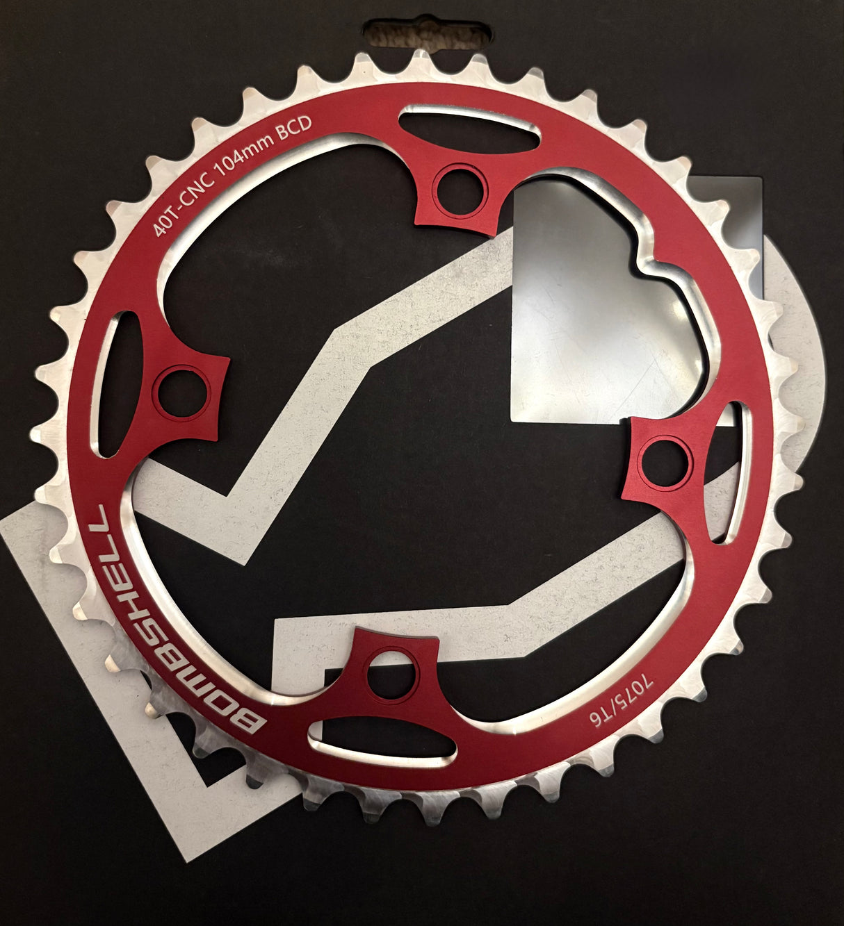 Bombshell Chainring by SSS Racing in red aluminum with 104mm BCD, silver teeth, bold cutouts and CNC finish. high polish