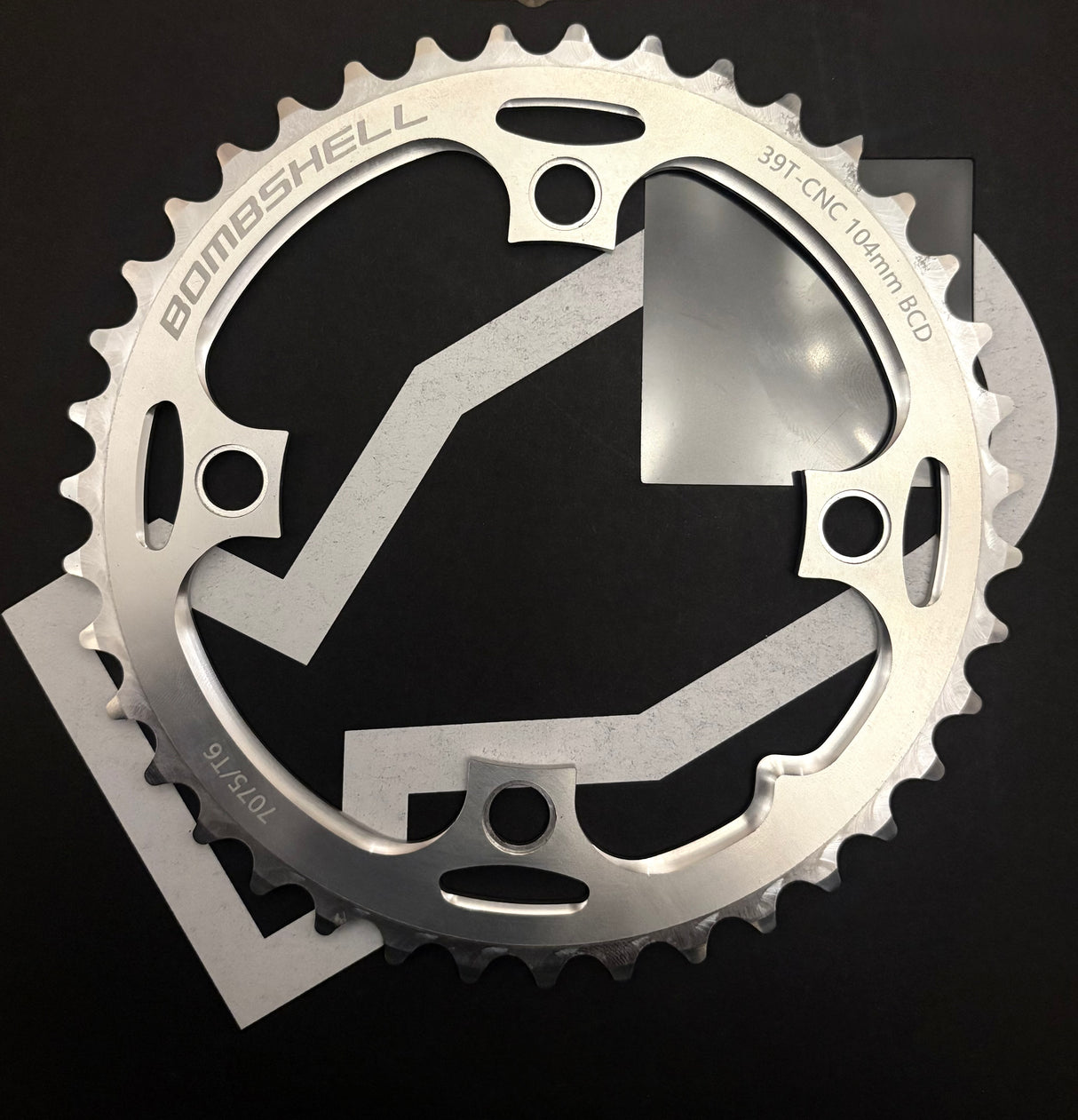 Bombshell Chainring by SSS Racing in silver aluminum, polished finish with cutouts and bold, CNC-machined tooth profile.