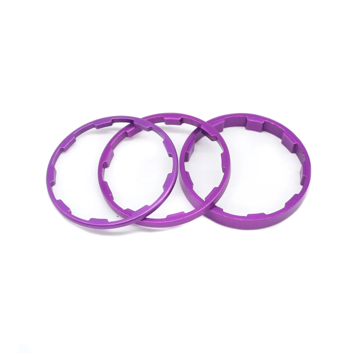 Yoshoka Sprocket Spacers Kit by SSS Racing: vivid purple anodized aluminum rings with notch-teeth, precise fit, durable.