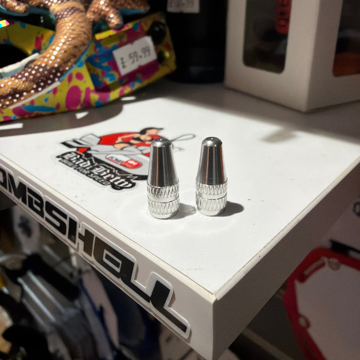 Aluminium Presta Valve Caps in silver, knurled cylindrical tops with diamond-cut grip, three caps upright on white surface.