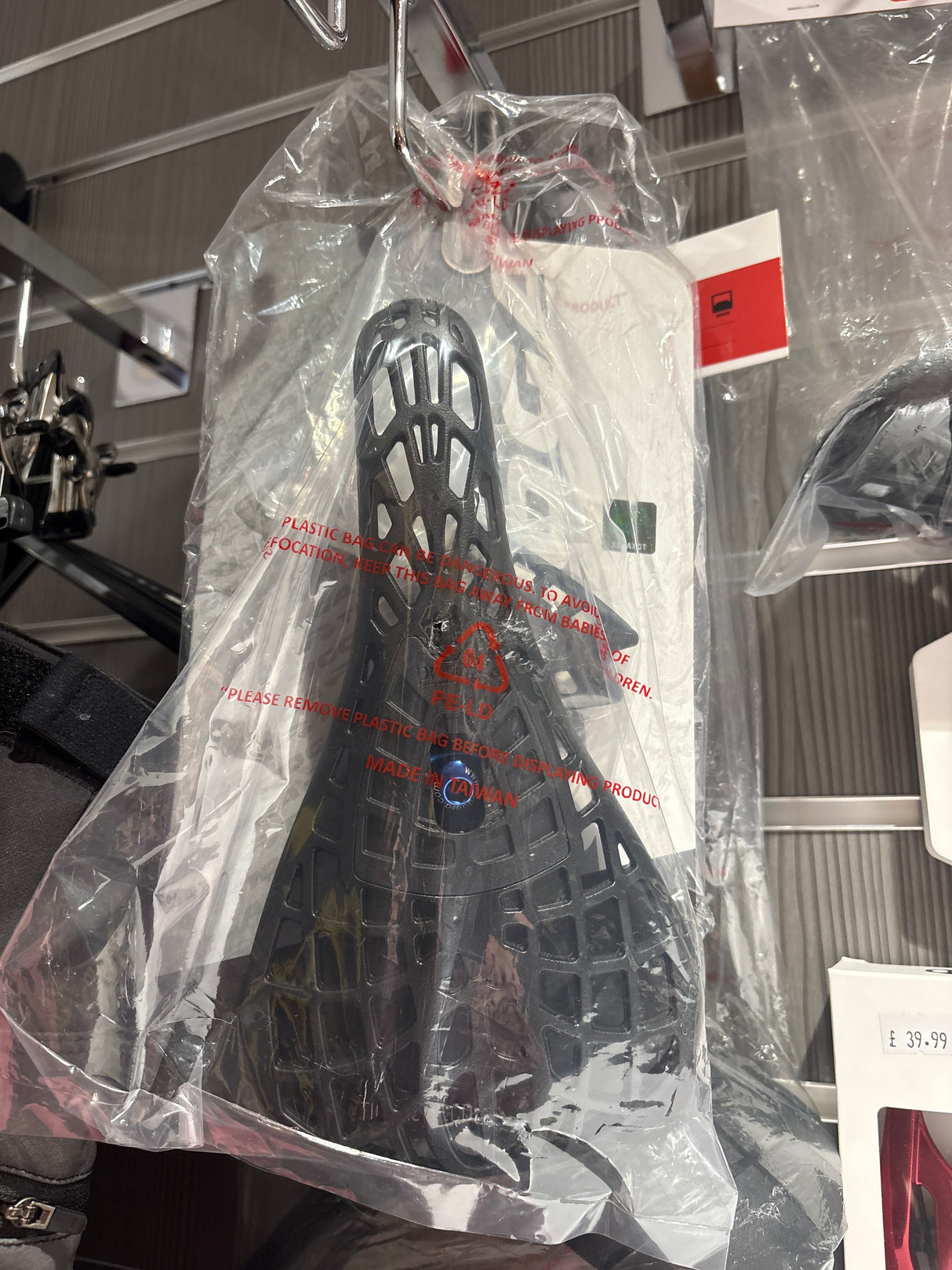 SSS Racing Tioga D-Spyder Saddle in black lattice polymer shell, orange accents, rugged cutout design, packaged for display.