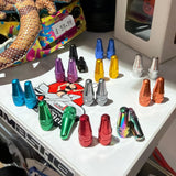 Aluminium Presta Valve Caps in assorted colors; conical, knurled barrels upright on a white display shelf with bright hues.