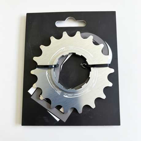 Bombshell Sprocket (Rear Cog): silver gear with jagged teeth, black mounting band, glossy metal detail on a dark box lid.