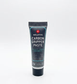 SSS Racing Carbon Fibre Gripper Paste tube: dark blue body, teal trim, silver cap, carbon graphics, 10g squeeze tube on desk