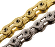SSS Racing KMC K1SL-N 3/32" Hollow Pin Chain with gold and silver plated links, polished metal pins, macro close-up detail.