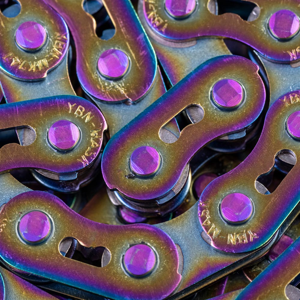 Gusset Oil Slick MX Chain 1/8" with oil-slick finish, aluminium links, purple bolts, rainbow tones. Ideal for BMX racing. 