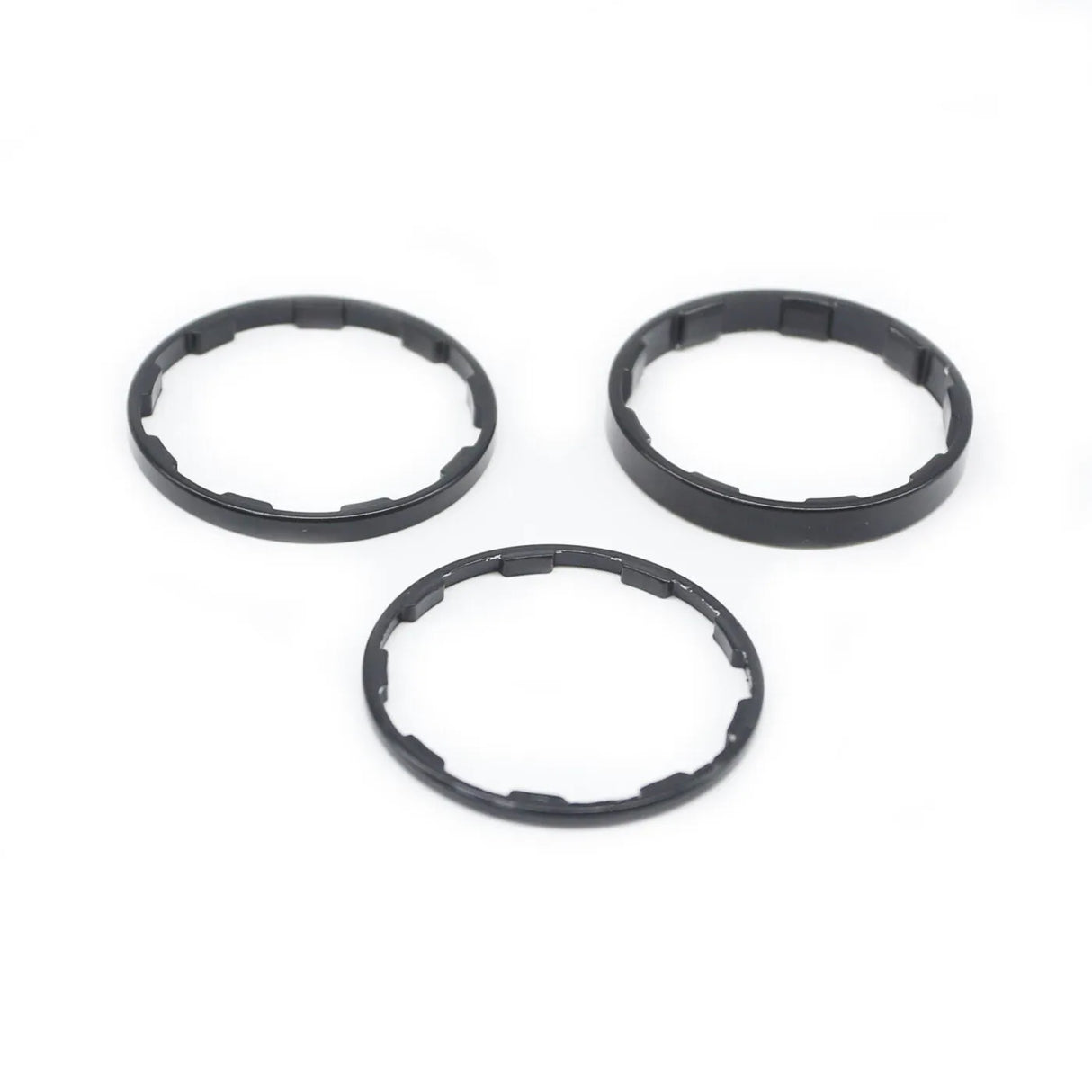 Yoshoka Sprocket Spacers Kit by SSS Racing: black anodized aluminum rings, 3mm thick, precise inner notches, matte finish.
